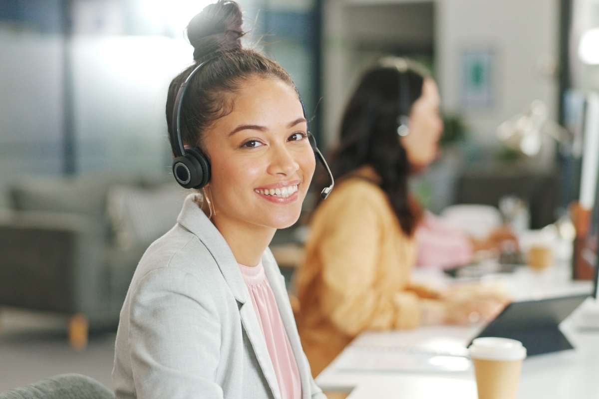 Woman on wireless headset smiling at work.